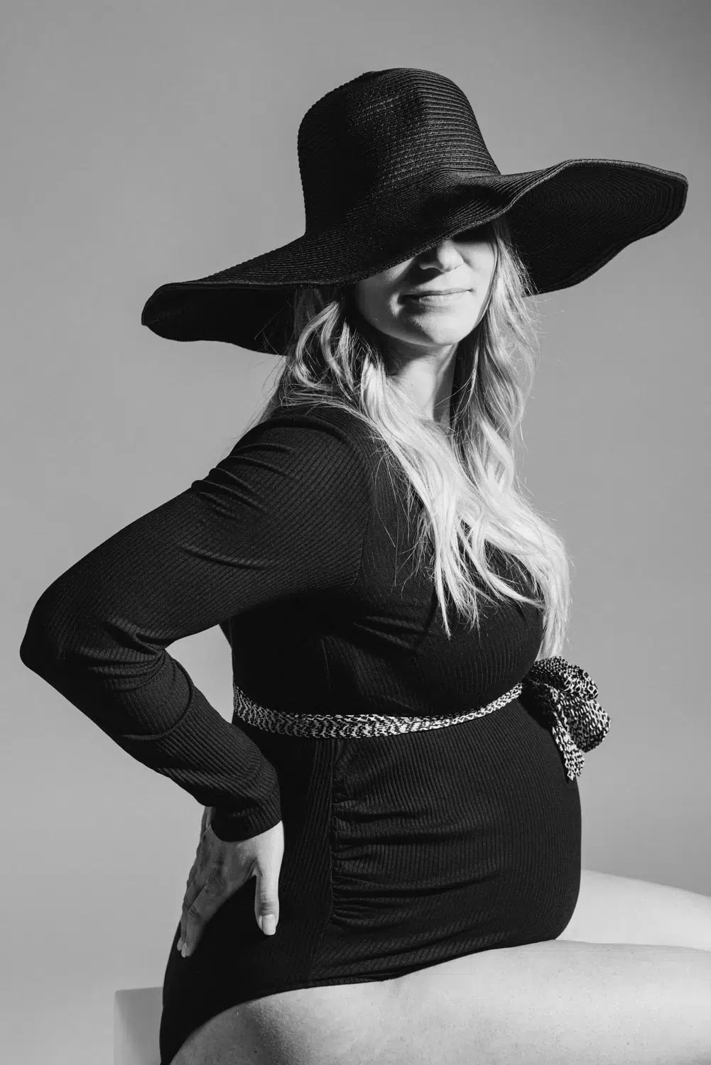 photo d'une femme enceinte en noir et blanc avec un chapeau en studio photo &agrave; grenoble