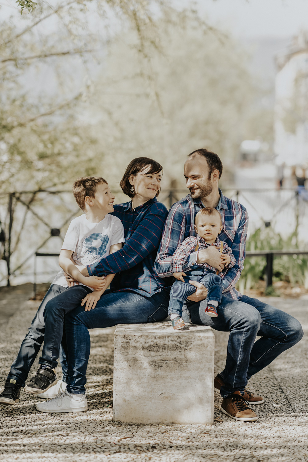 assis sur un banc, une famille pose pour une s&eacute;ance photo Life style sur les quais