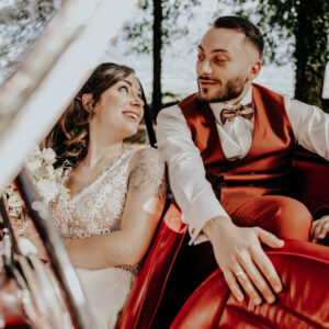 un couple de mari&eacute; dans une belle voiture rouge