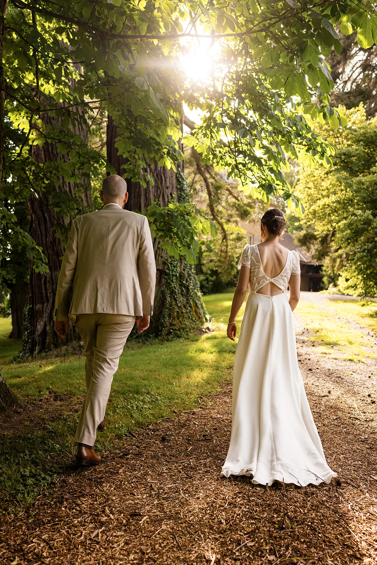 photo d'un couple de marié m'éloignât vers la lumière du soleil, photographe Mariage Grenoble