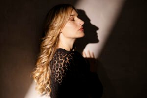 Portrait en studio photo d’une femme blonde, rayon de lumière, robe noire, par Utopikphoto photographe portrait grenoble