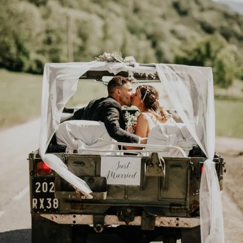 photo d'un couple de mari&eacute;s de dos, s'embrassant dans la voiture