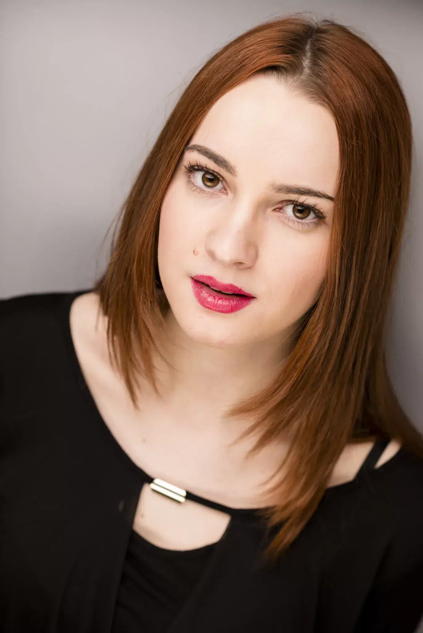 Portrait studio serr&eacute; &agrave; Grenoble &mdash; femme rousse cheveux lisses rouge &agrave; l&egrave;vres framboise, fond gris, &eacute;clairage doux &mdash; photo book et CV Utopikphoto
