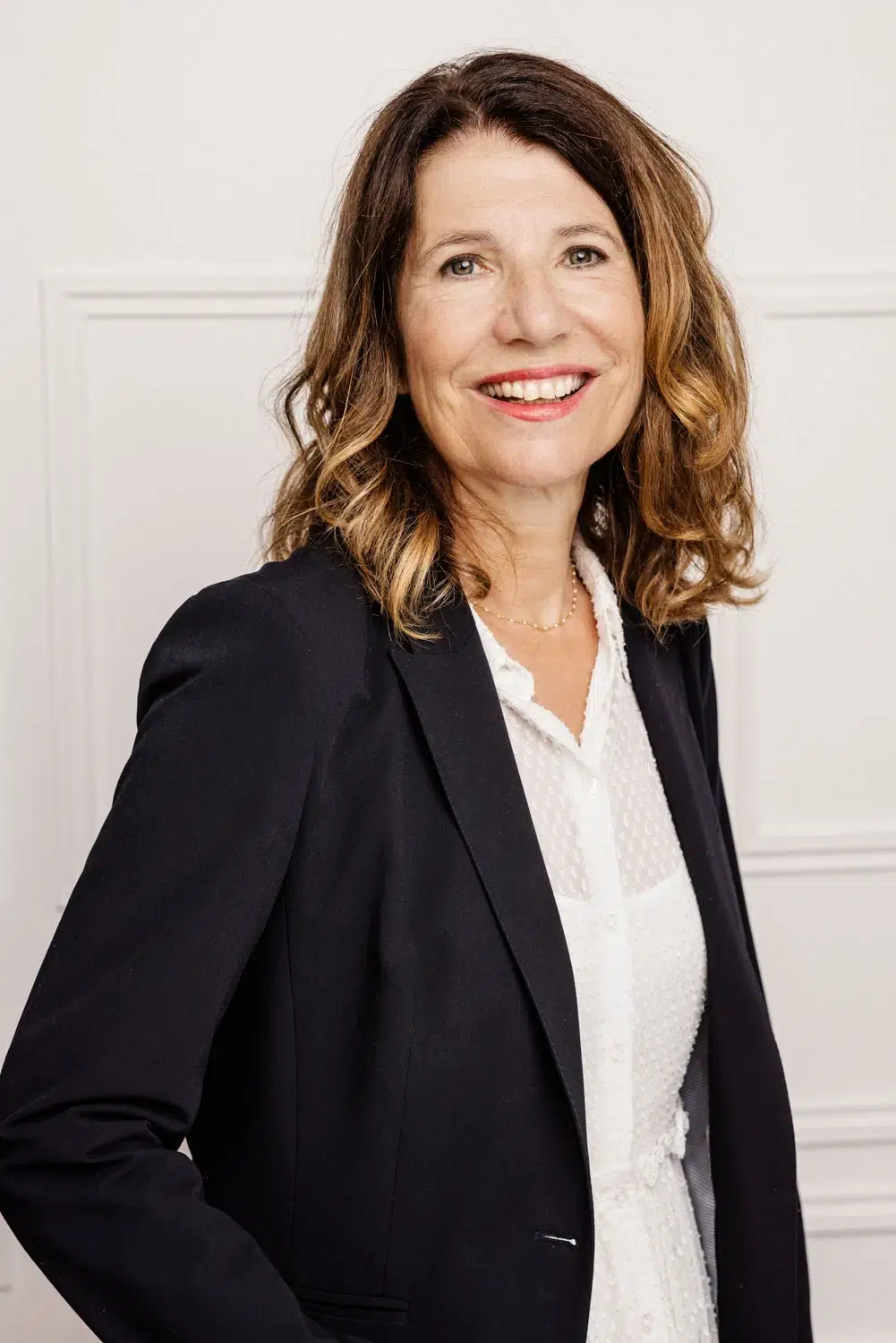 Portrait LinkedIn et CV femme &agrave; Grenoble &mdash; blazer noir chemisier blanc, fond boiserie clair, sourire naturel &mdash; photographe corporate Utopikphoto