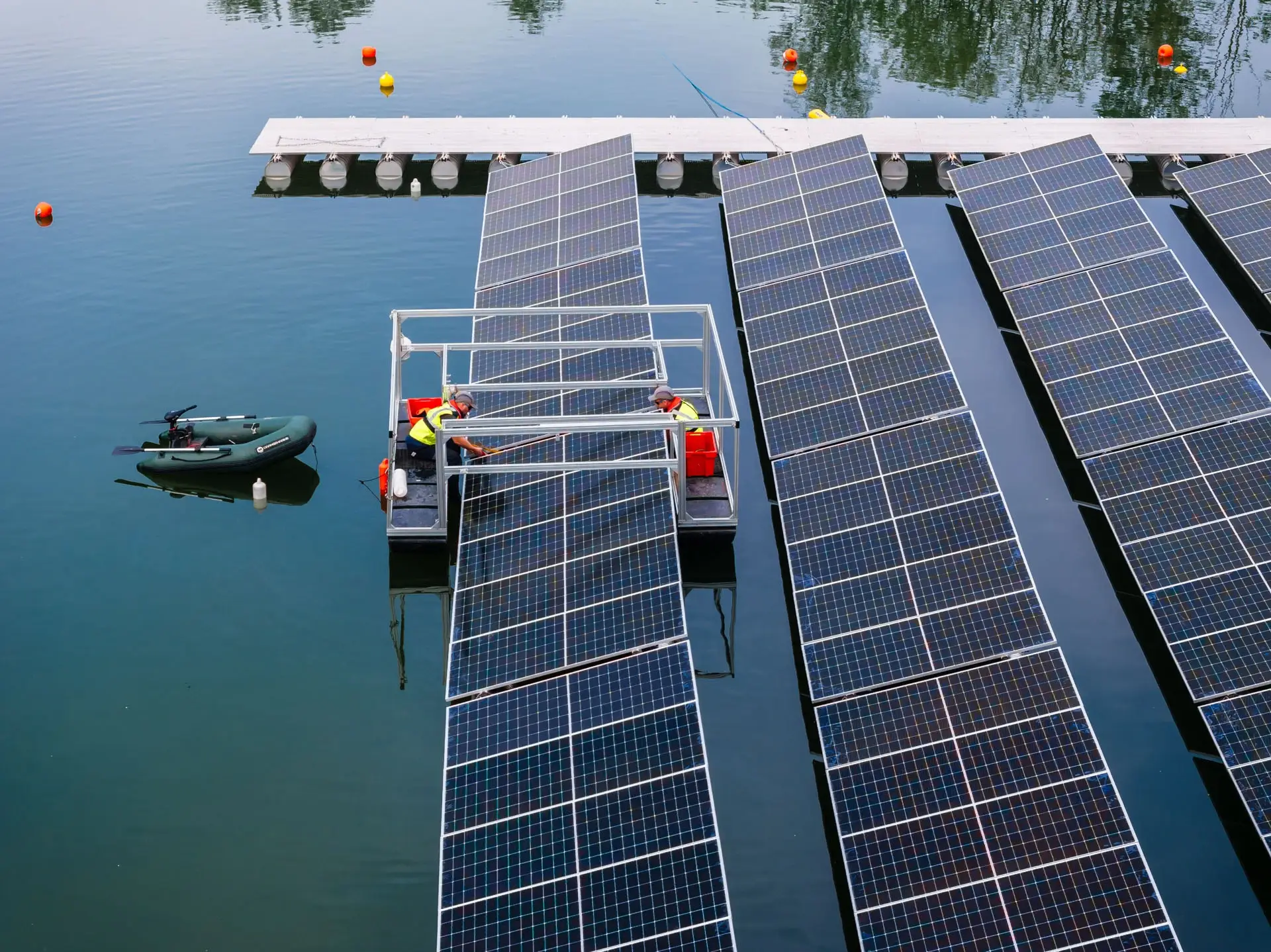 Plateforme d'assemblage et bateau pneumatique au milieu des panneaux solaires flottants