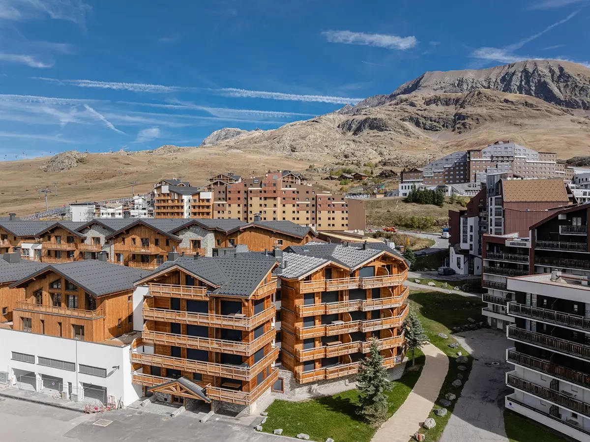 photo d'un ensemble immobilier à l'alpes d'huez avec la vue sur les montagnes de l'Oisans en arrière plan
